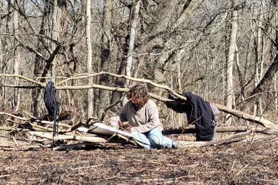 student surrounded by trees