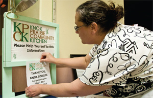 Laurie Sauer, information technologies librarian at Knox's Seymour Library and secretary for the KPCK,<br />posts a flier thanking Knox College for sponsoring the May 3, 2012, meal.