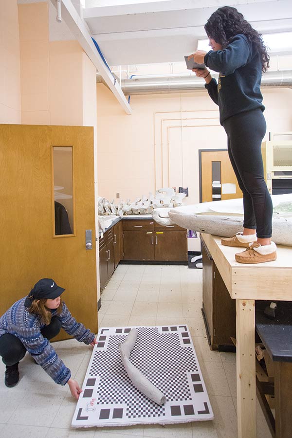 Senior Kiana Arango rotates the whale’s hyoid (tongue bone) while Sam Arrez ’19 takes photos with an iPad. The photos will be used to create a digital 3D surface model of the bone.