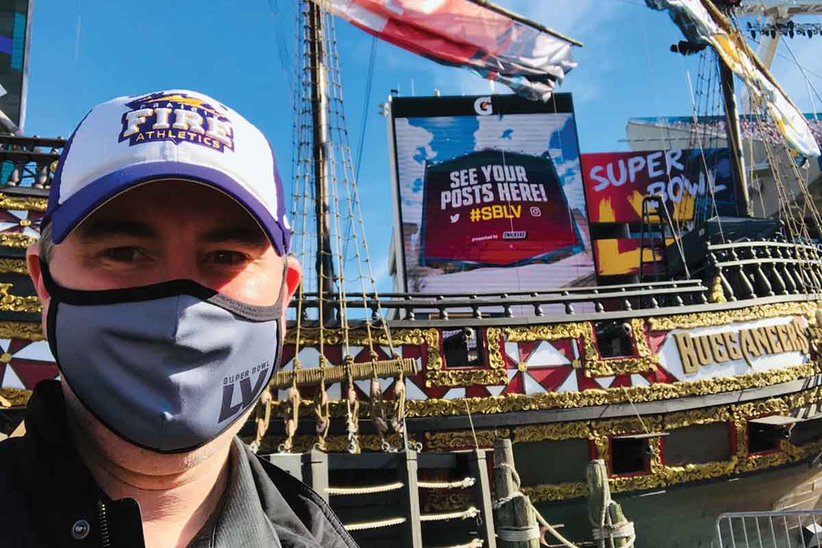 Andrew Isaacson ’99 takes a gameday selfie with one of the enormous video displays he managed during the game.