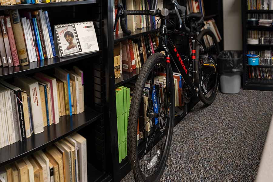 Julio's bike leaning against a large bookcase in his office.