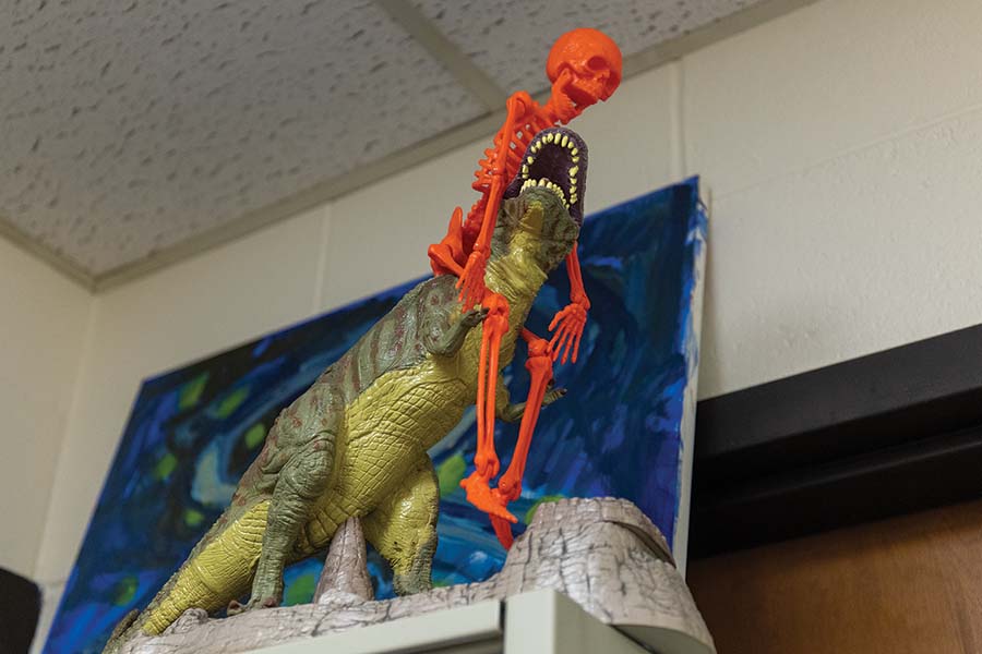 A toy skeleton riding on a toy T-rex.