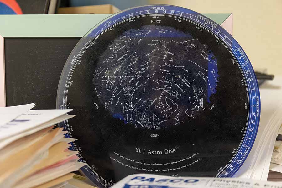 A planisphere disc that is black and blue sitting on Nathalie's desk.