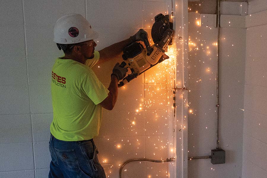 A construction worker working with a saw in the residence halls.