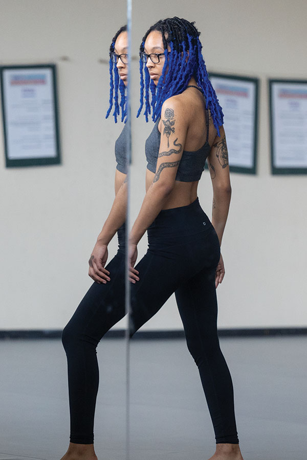 Aicha Chehmani dancing in front of a mirror.