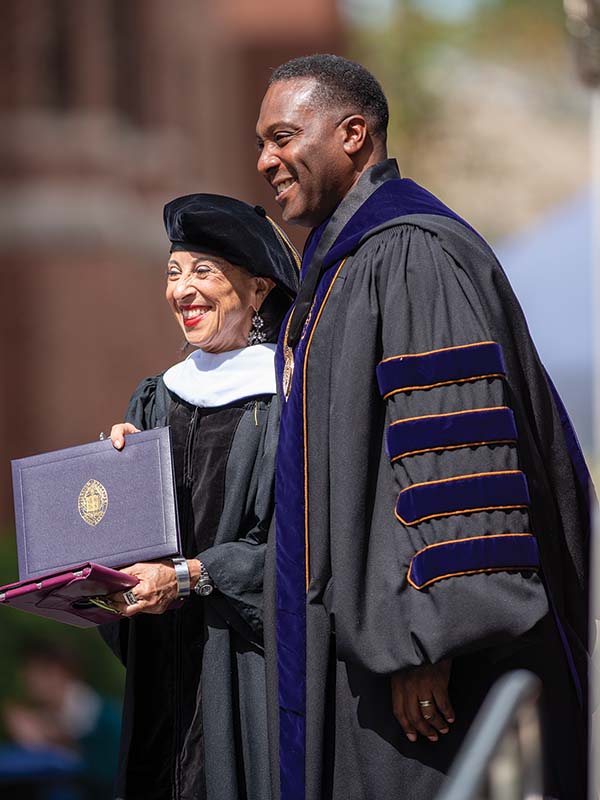 Maria Hinojosa and President C. Andrew McGadney smile while Maria receives her honorary degree.