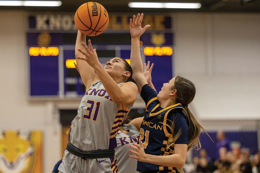 Kylee Callahan jumps to make a basket as another player from the opposite team jumps with her.