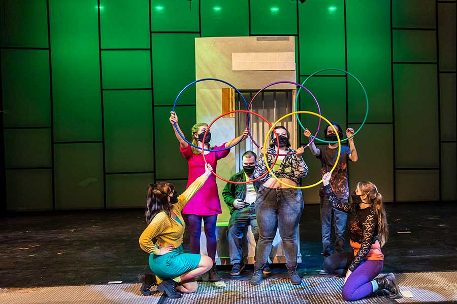 Students in Repertory Theatre Term on the stage with a green wall behind them