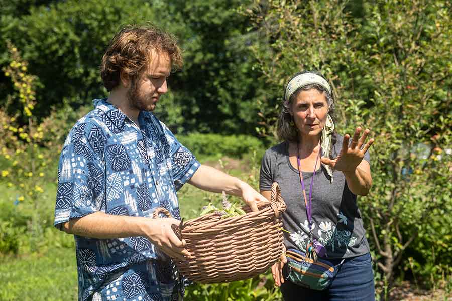 Tina Hope and a student harvesting herbs.