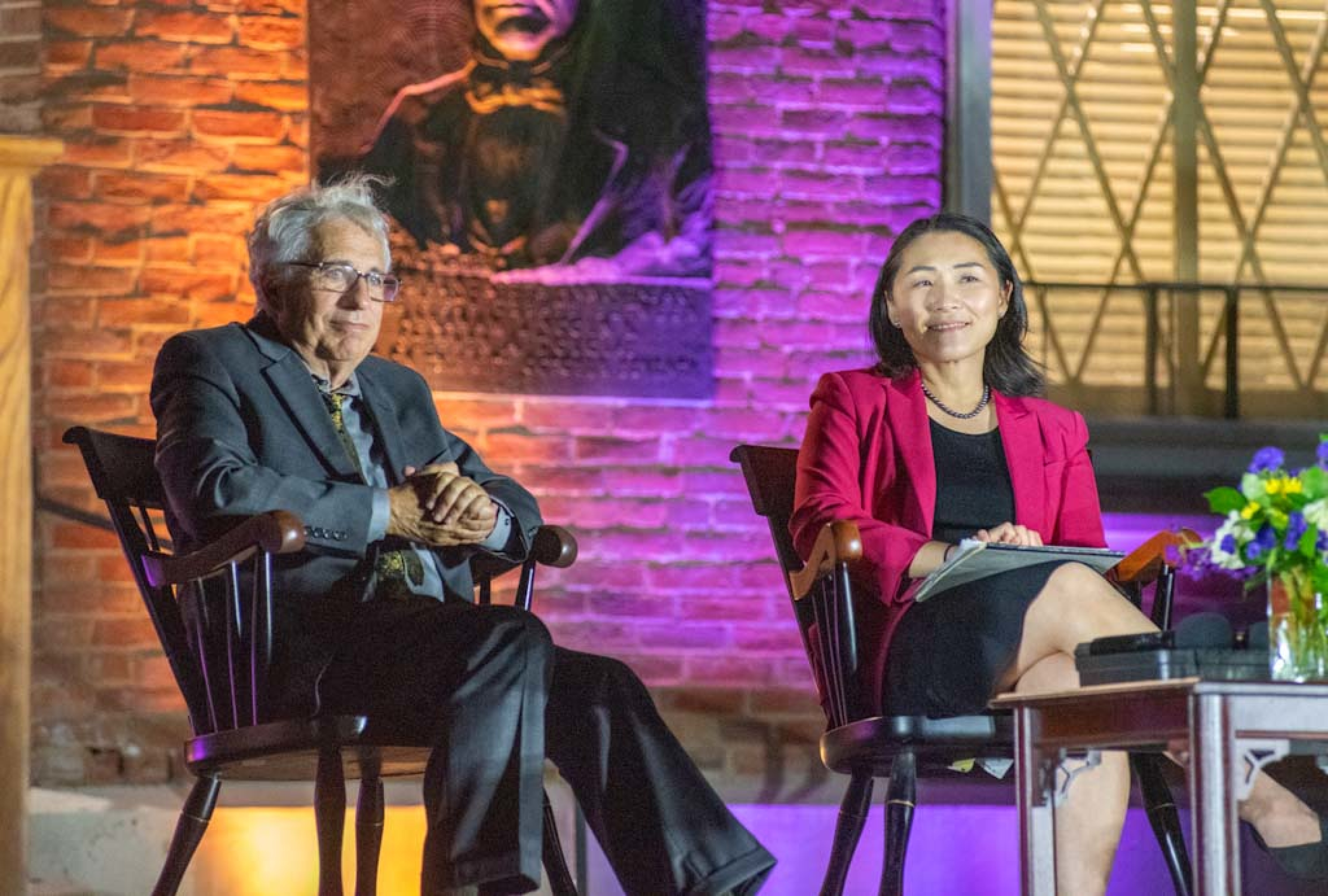 Jeffery Tulis, left, and Julie Suk, right, enjoy a round of applause following their debate.