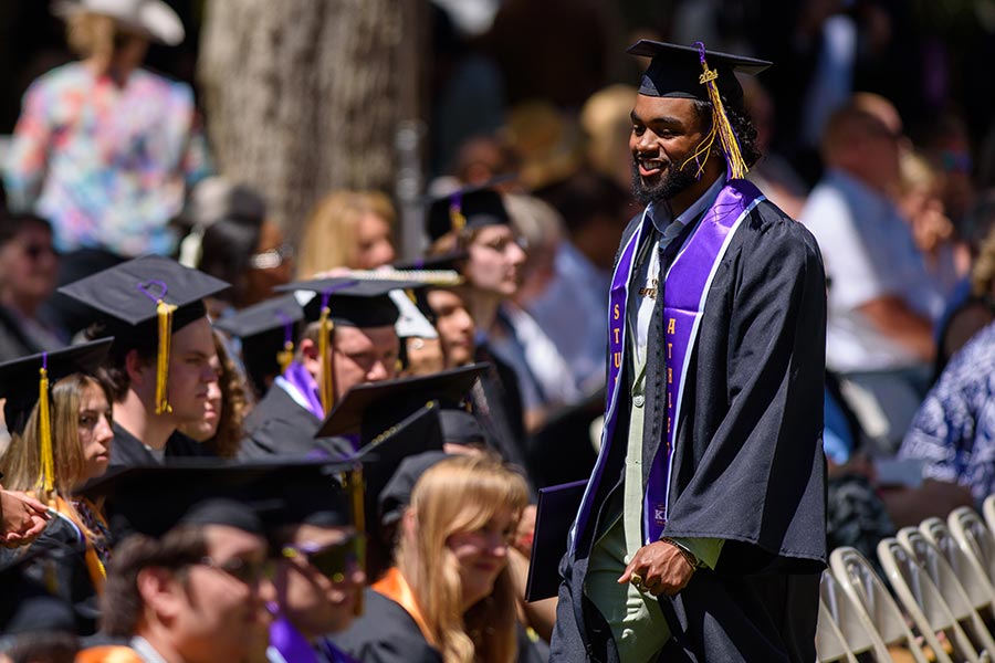 A students standing in the crowd applauding.