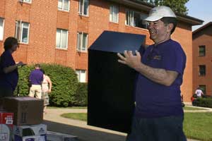 Roger Taylor carries furniture for student