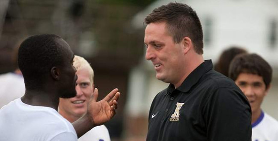 Soccer coach Matt Edwards talks to sophomore midfielder Abdulsalam Oganla after the Prairie Fire defeated Grinnell 2-1 in overtime.