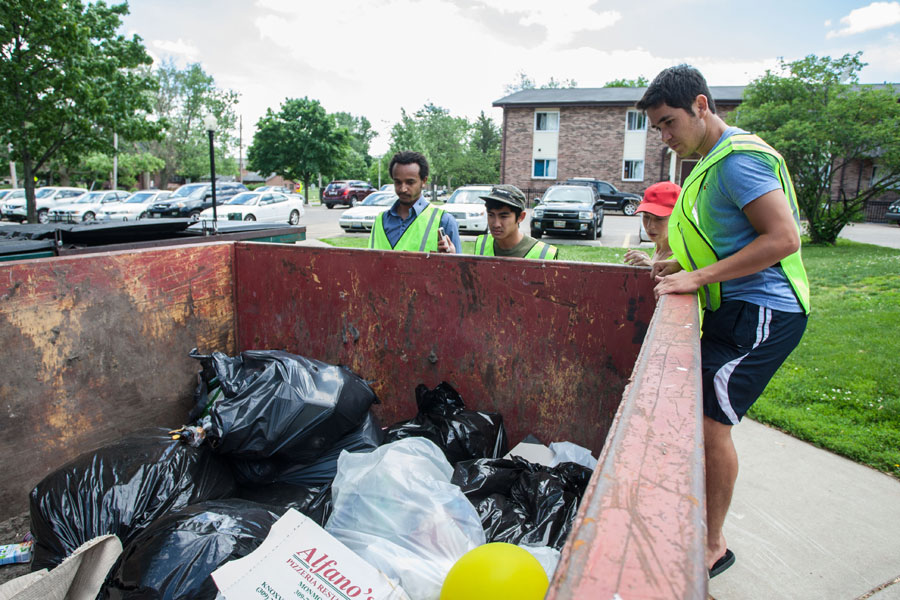 Students check dumpsters during a year-end recycling campaign.