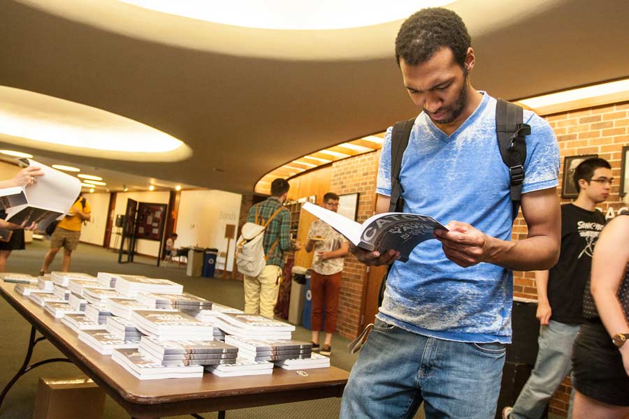 Students looking at Spring 2011 issue of Catch, at the literary magazine's release party in the CFA lobby.