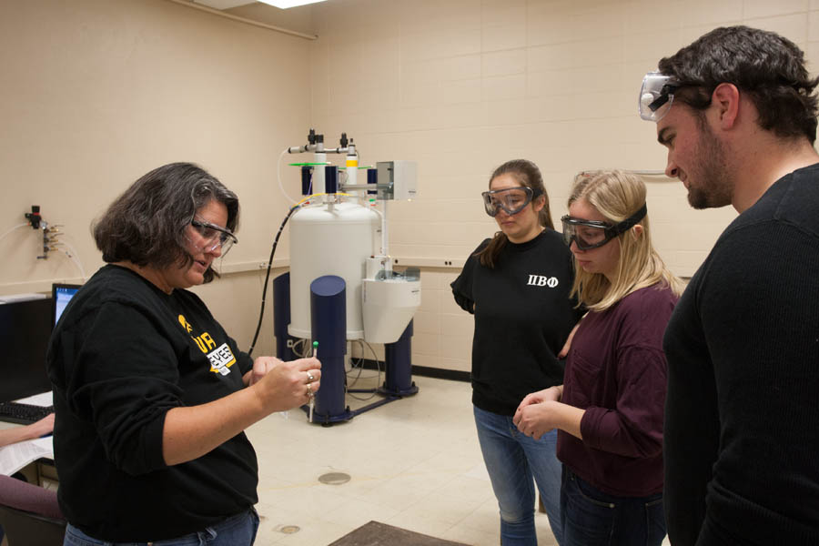 Professor Diana Cermak in the Knox College Chemistry Department's NMR lab shows students how to prepare samples for the new nuclear magnetic resonance spectrometer, acquired through a research equipment grant from the National Science Foundation.