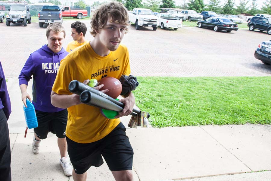 Knox College student Chris Colburn helping deliver books and recreational items to the Boys and Girls Club of Knox County.