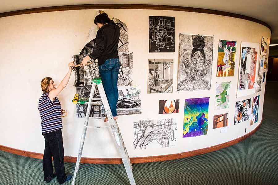 Student holds up a drawing to be entered in the 2017 Al Young Art Show.