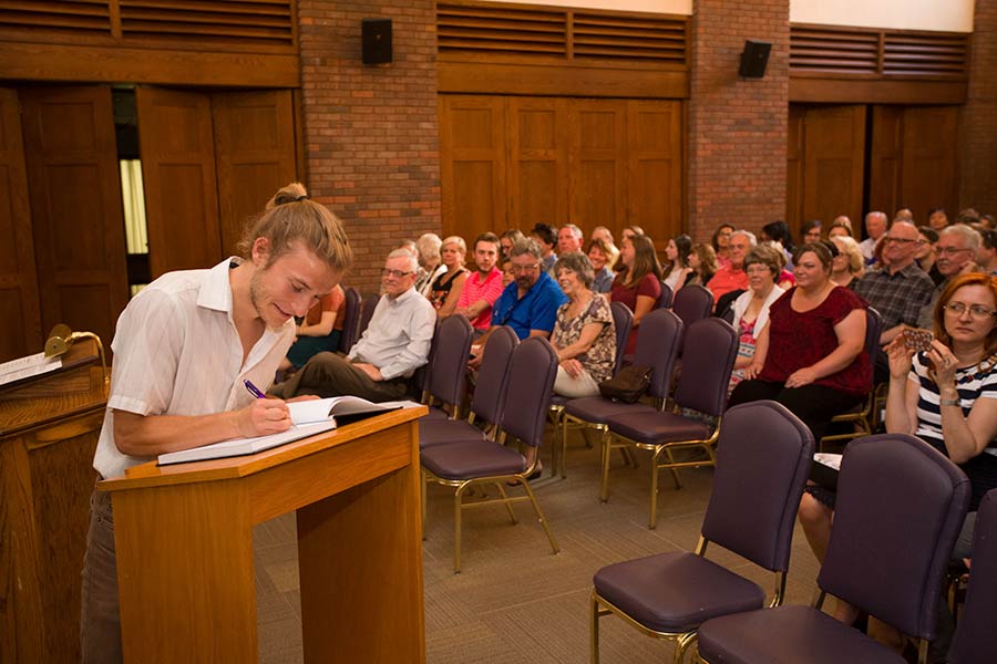 Newly inducted Phi Beta Kappa members sign the new black leather-bound book.