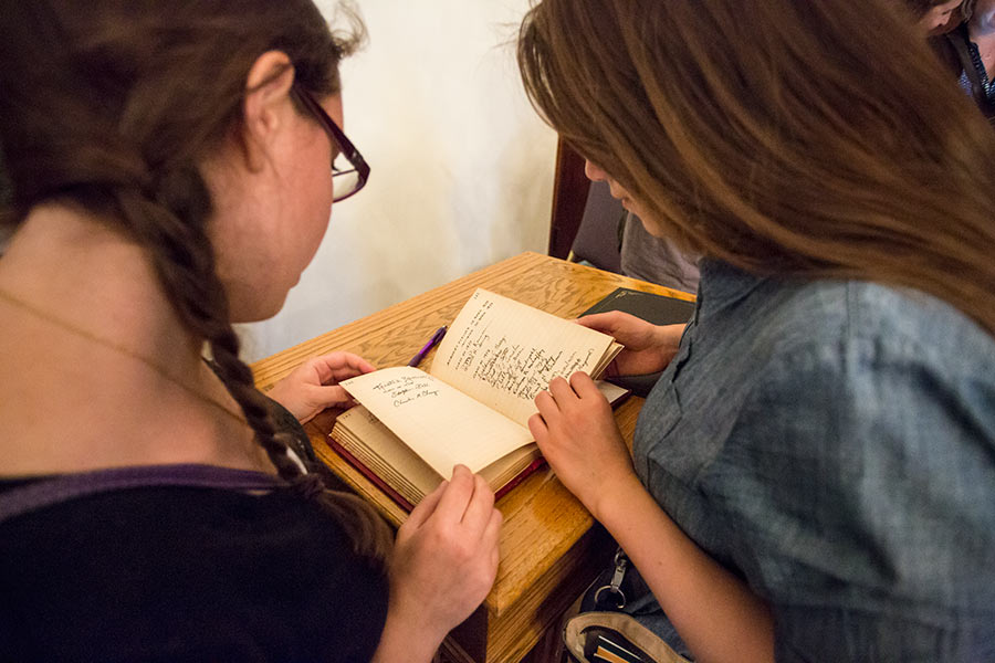 Students look at signatures in the Phi Beta Kappa book.