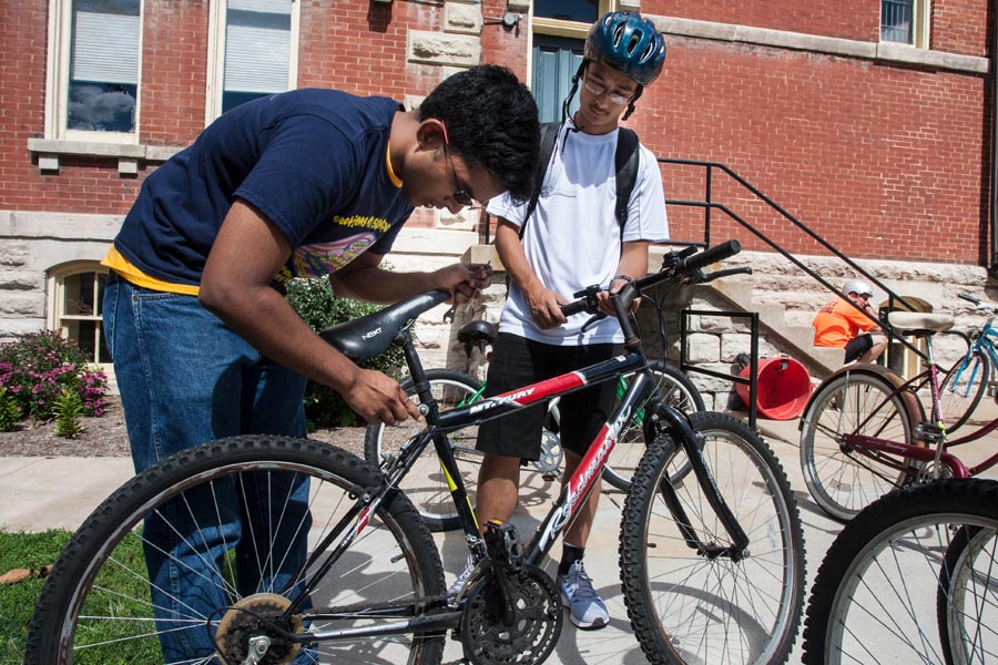 Student mechanic adjusting a bicycle at the Knox College Bike Shop