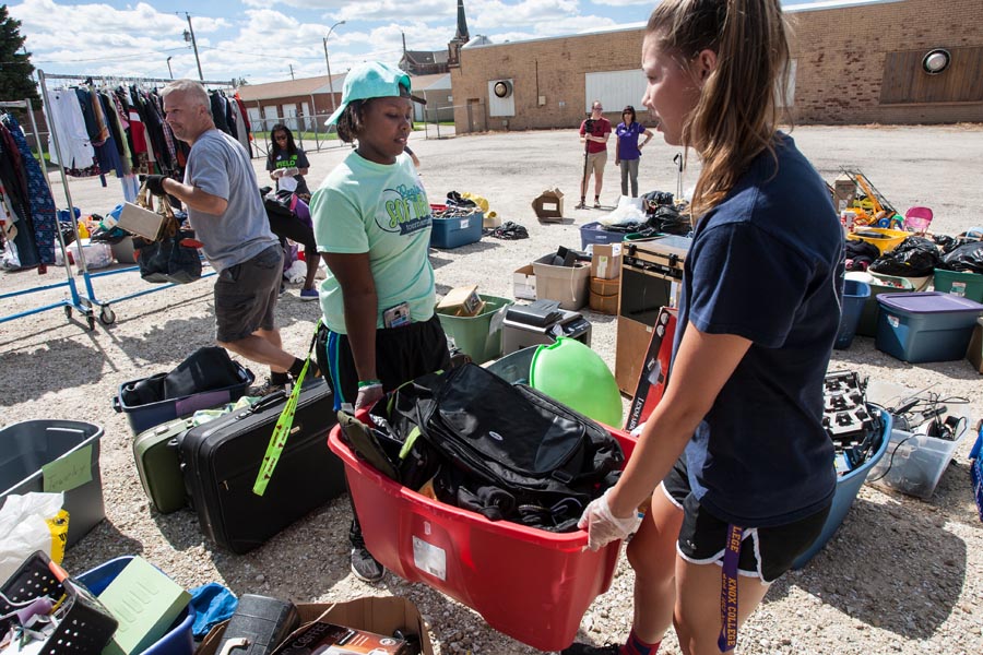 Knox College students help sort materials at the Purple Hanger resale shop, to benefit Safe Harbor Family Crisis Center.