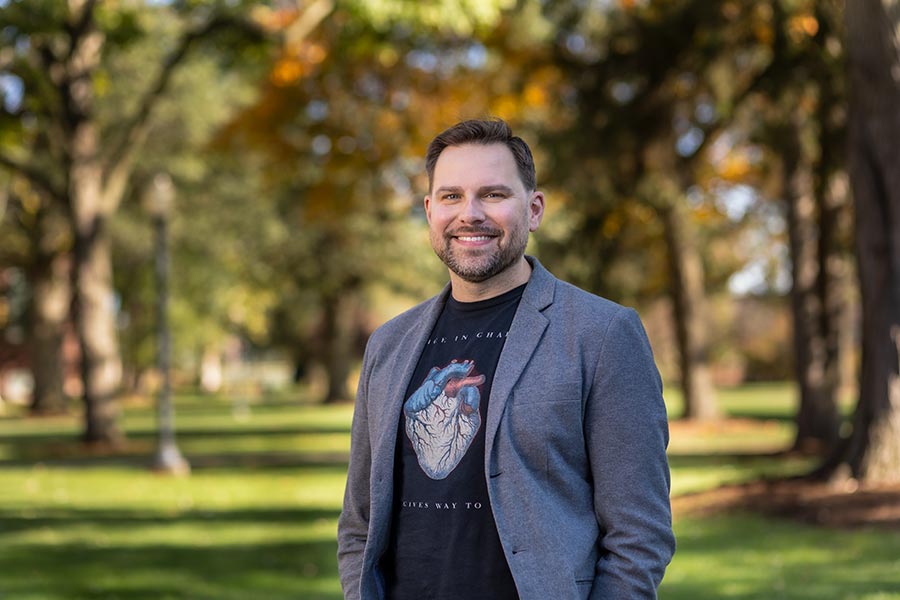 Brandon Polite, philosophy professor, stands among trees on campus