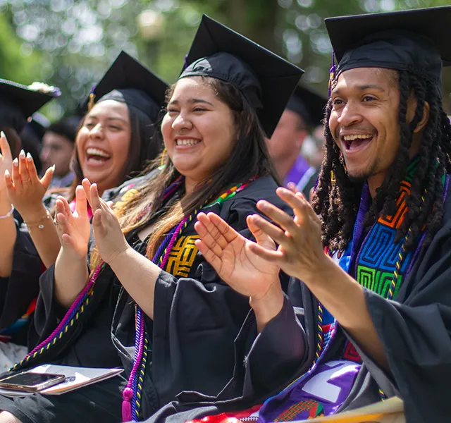 Graduates celebrating and clapping at the 2024 Knox College Commencement.