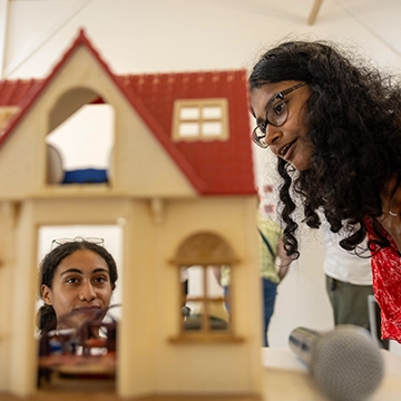 Two Knox College students examine a child's doll house during a immersive course.