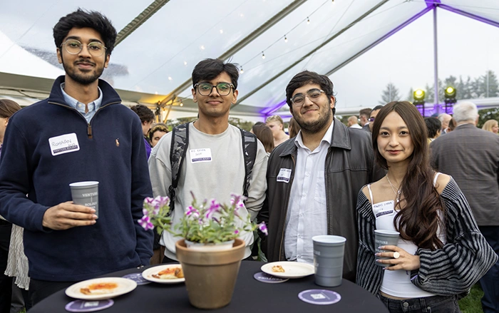 Four event attendees smile at the camera.