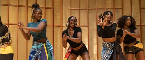 Four students perform an African dance at Knox College.