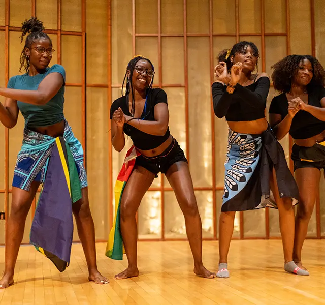 Four students perform an African dance at Knox College.