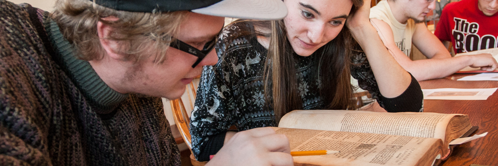 Students in a greek class examine ancient books in Seymour Library.