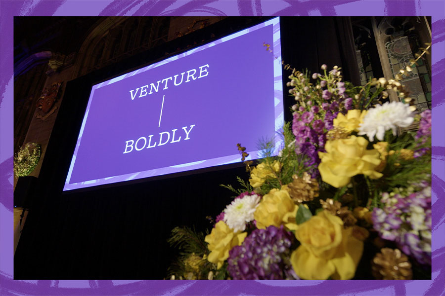 image of yellow, purple, and white flowers with large screen in background displaying text "VENTURE BOLDLY"